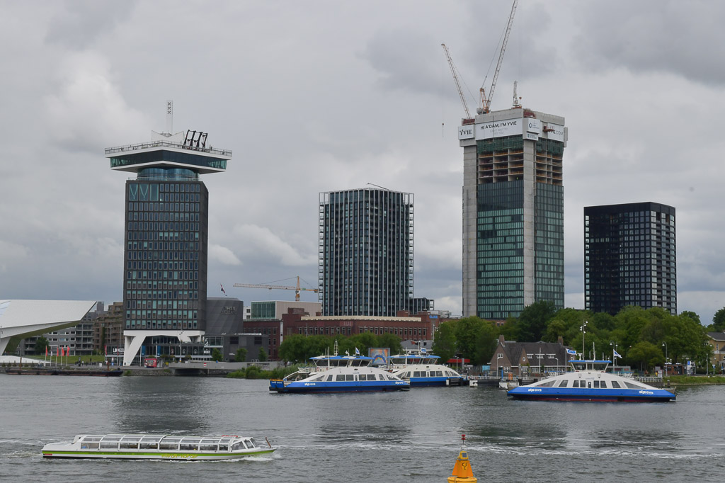 Die Türme des A'DAM Tower und der Nachbargebäude am Nordufer des IJ mit Fähren im Vordergrund