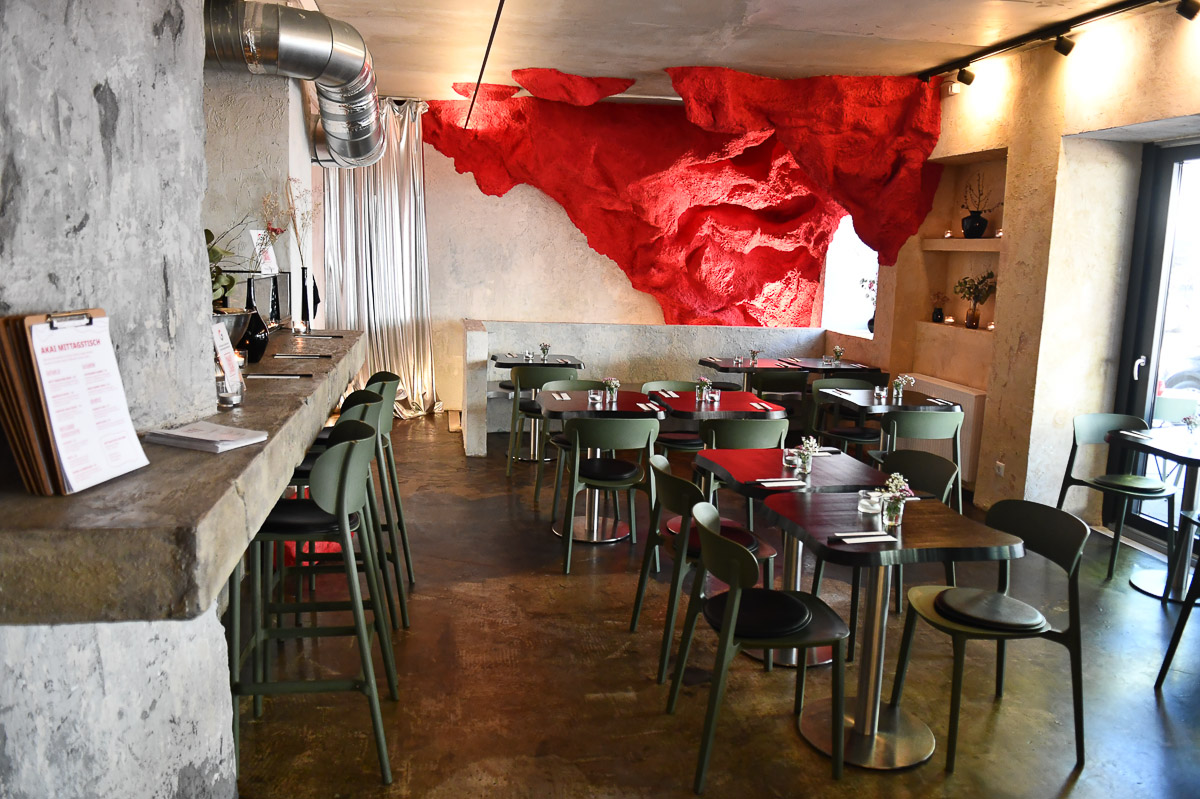 Gastraum mit roter Wandinstallation in Felsenform