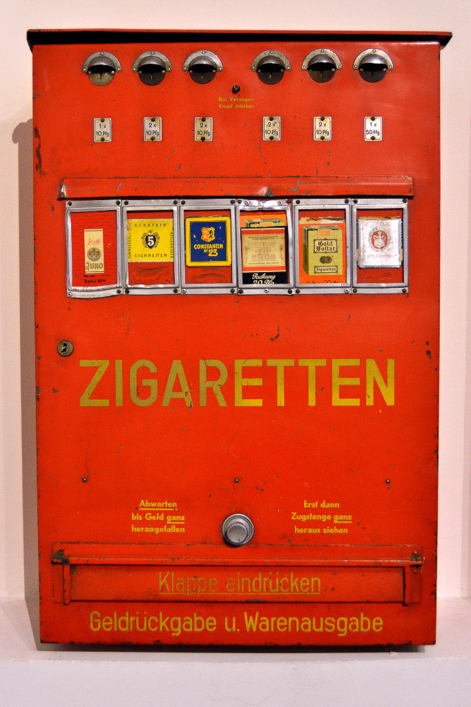 Zigarettenautomat und alte Dosen im Hochformat