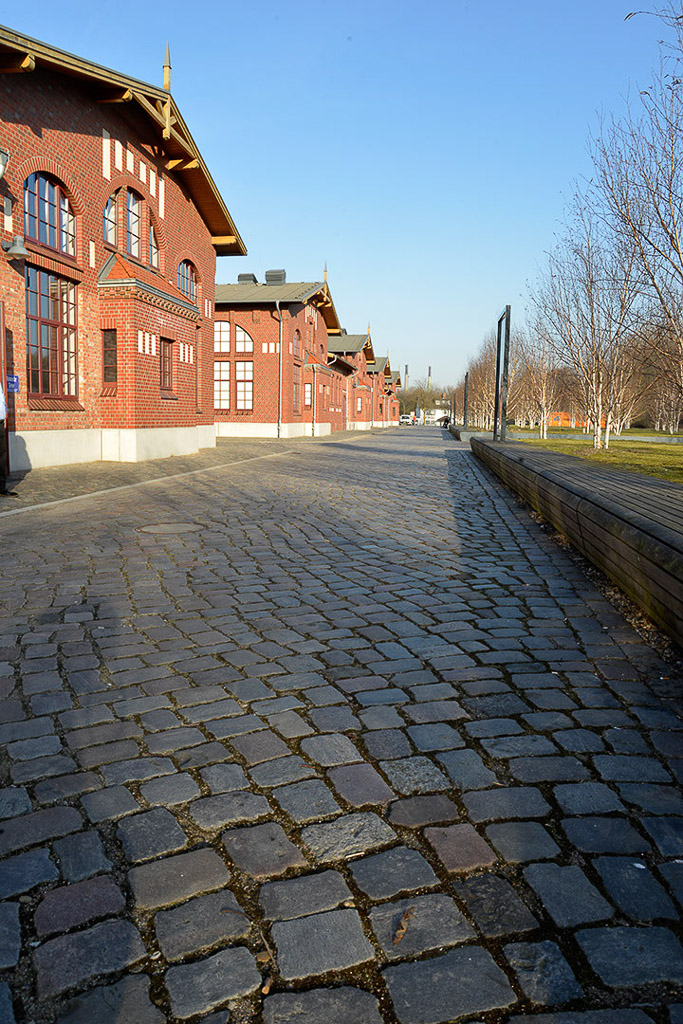 Gepflasterter Weg an den Hallen im Hochformat