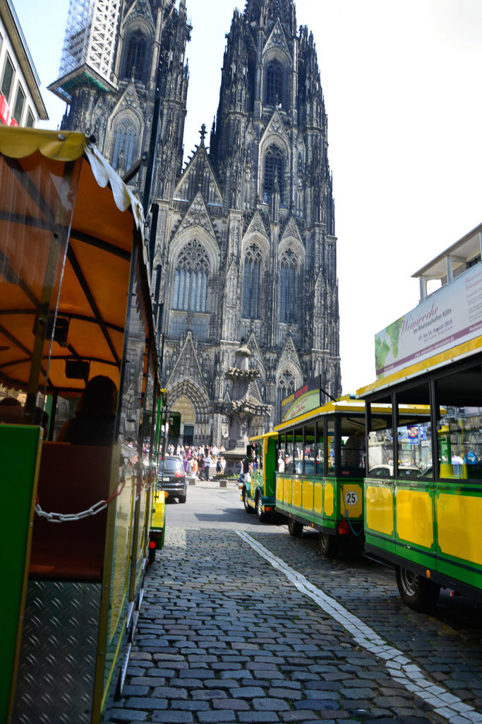 Bimmelbahn in einer Gasse mit Dom im Hochformat