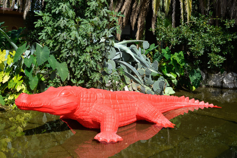 Rotes Krokodil als Skulptur im Teich
