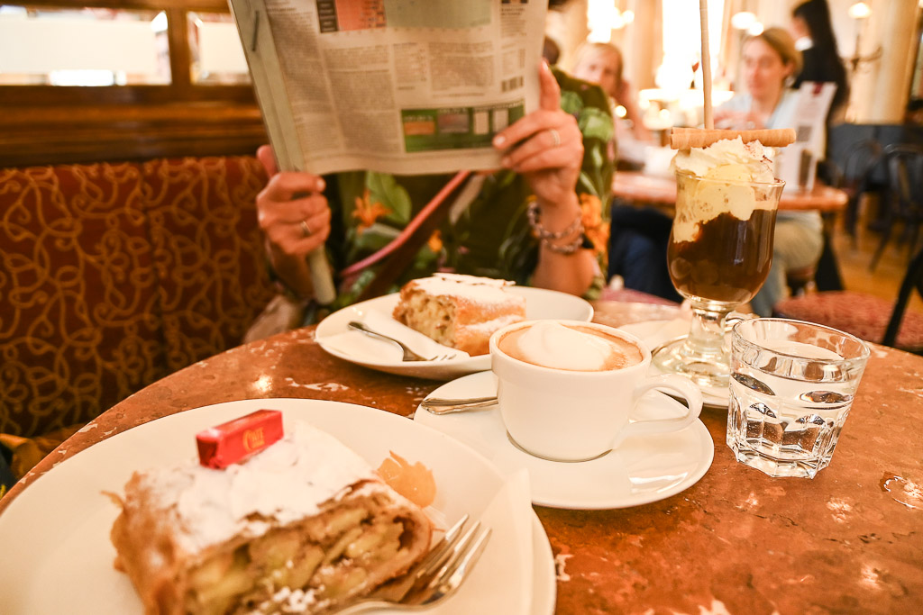 Kaffee und Kuchen auf dem Tisch mit Zeitung