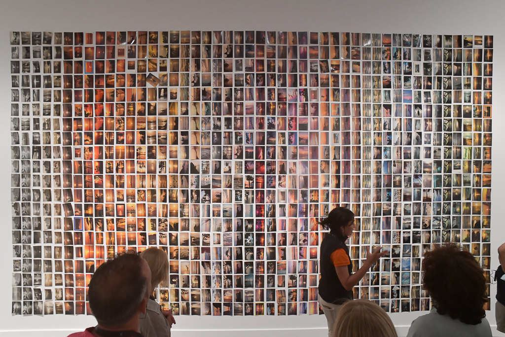 Wand mit vielen kleinen Fotos und Besuchern