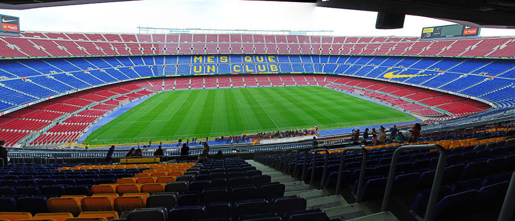 Blick auf das Camp Nou mit rot-blauen Rängen und dem Rasen