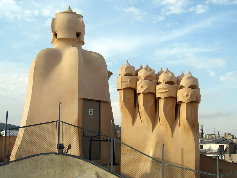 Skulpturale Kamine auf dem Dach der Casa Milà vor blauem Himmel