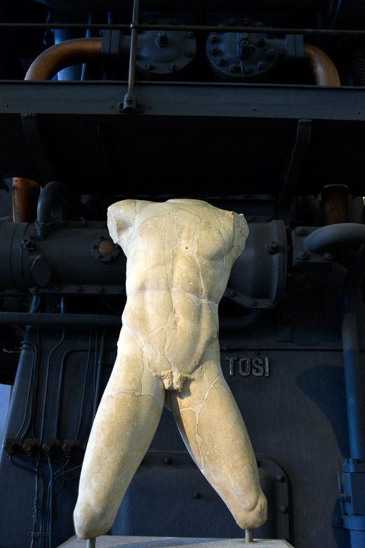 Marmortorso vor einer Maschine im Hochformat