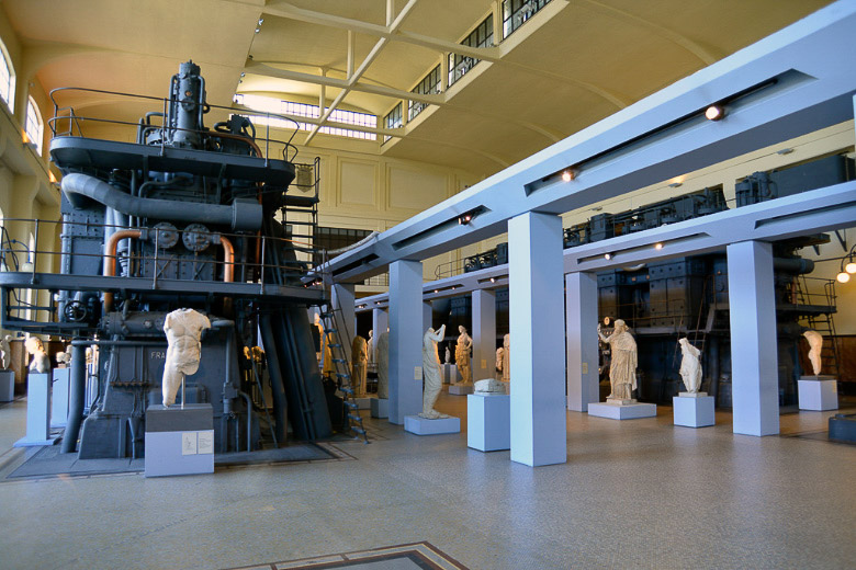 Statuen zwischen Maschinen in der Halle