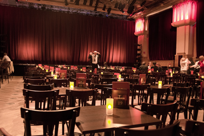 Festsaal des Chamäleon Theaters mit Bühne und Tischen