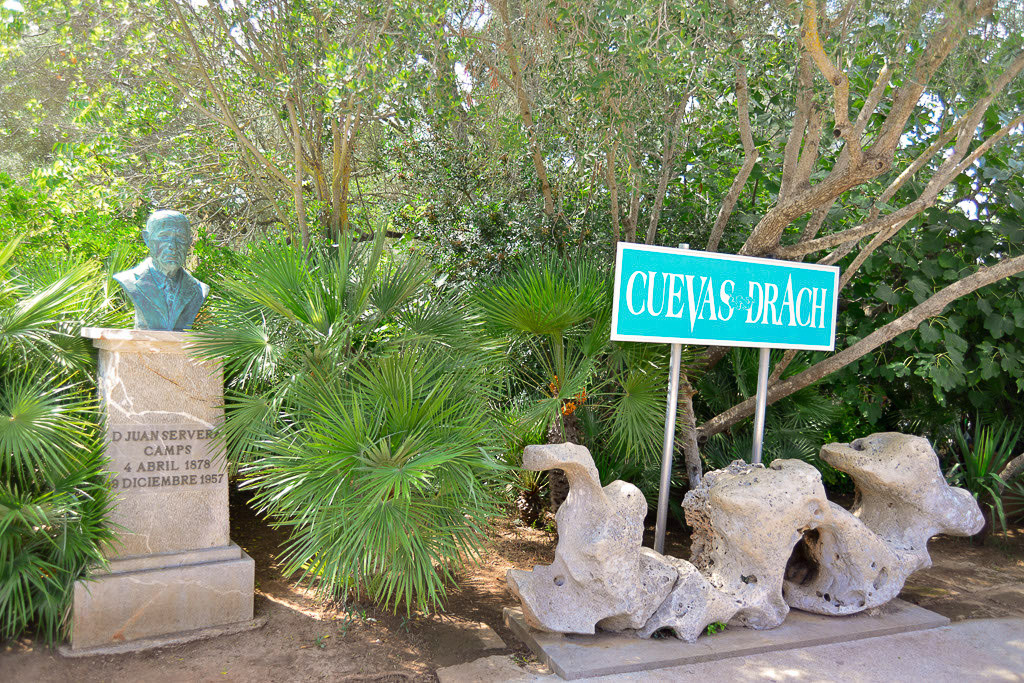 Hinweisschild Cuevas del Drach mit einem Denkmal