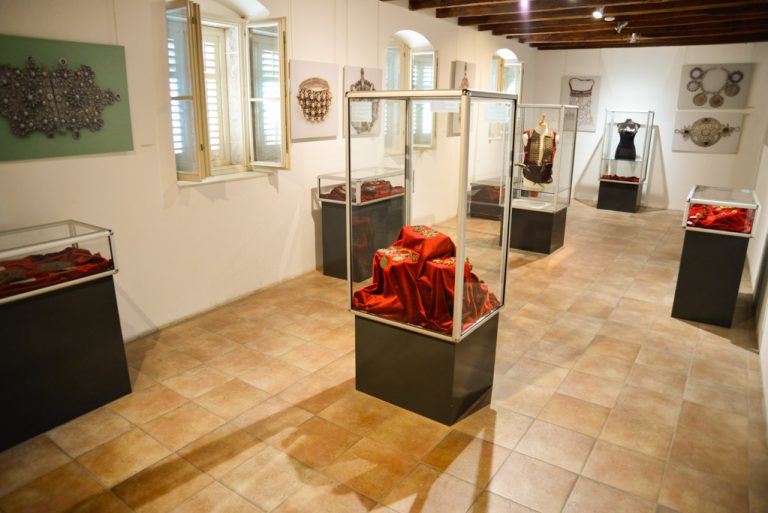 Ausstellungsraum mit Vitrinen und Trachten