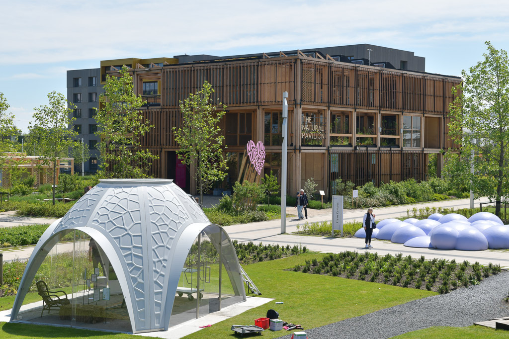 Gebäude aus Holz und ein weißer Pavillon im Park der Floriade