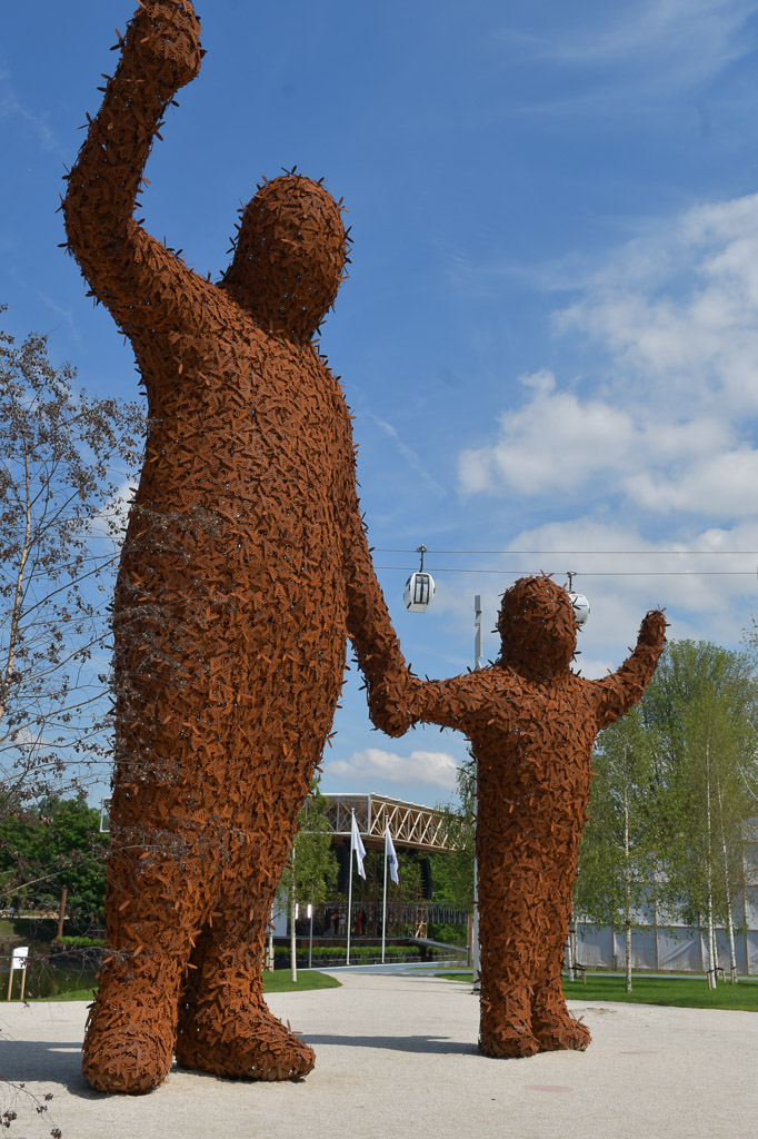 Skulptur aus Zweigen: ein Riese mit einem Kind an der Hand
