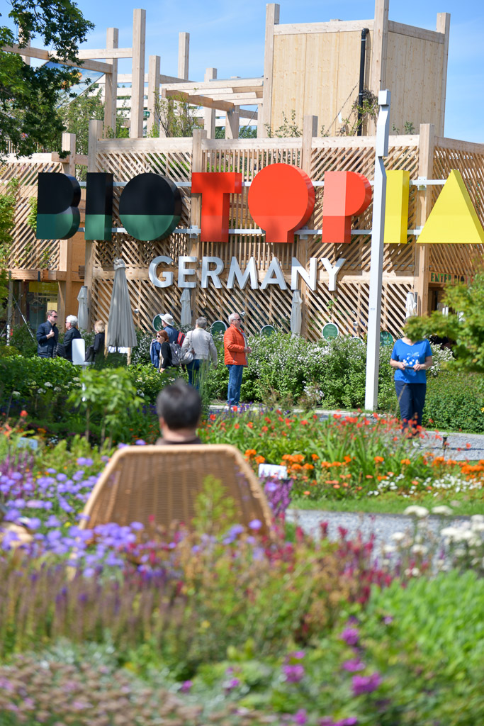 Eingang des deutschen Pavillons mit Blumenbeeten