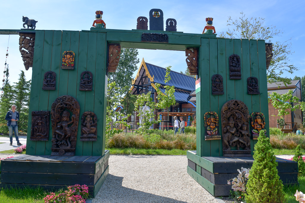 Grünes Tor mit Figuren in einem Garten der Floriade