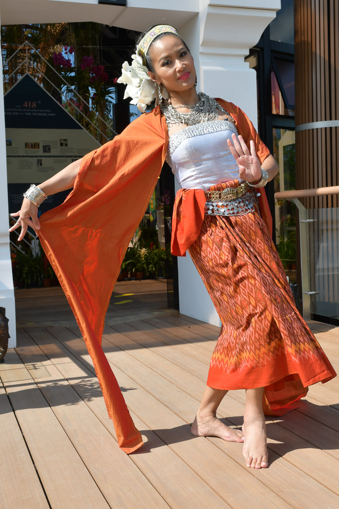 Tempeltänzerin in orangefarbener Tracht im Pavillon von Thailand
