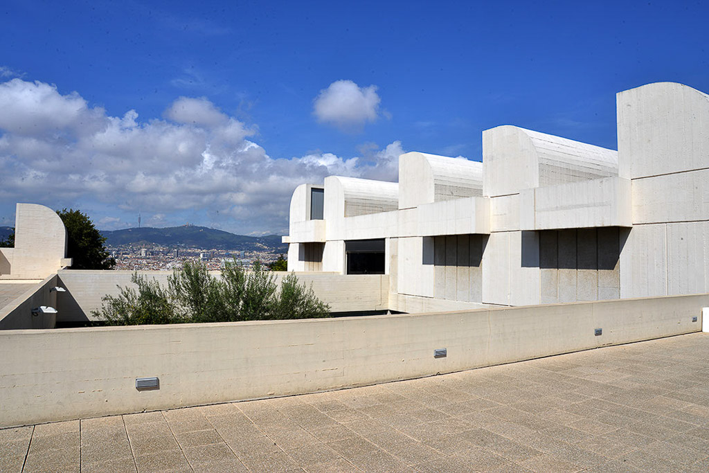 Weißes Museumsgebäude mit Terrassen unter Wolkenhimmel