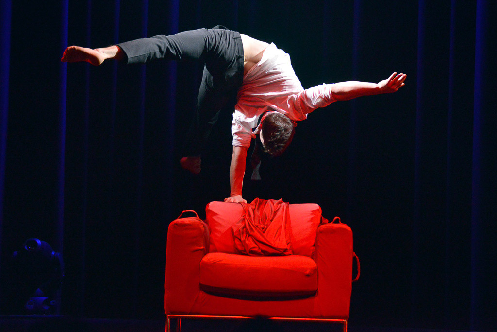 Handstand auf einem roten Sessel