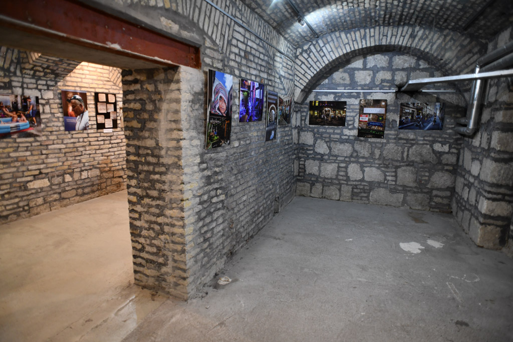 Ausstellungsraum mit Mauerwerk und Fotos