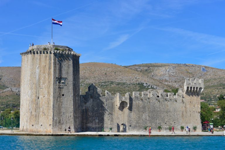 Die Festung Kamerlengo mit Turm und Mauern am Wasser, darauf die kroatische Flagge