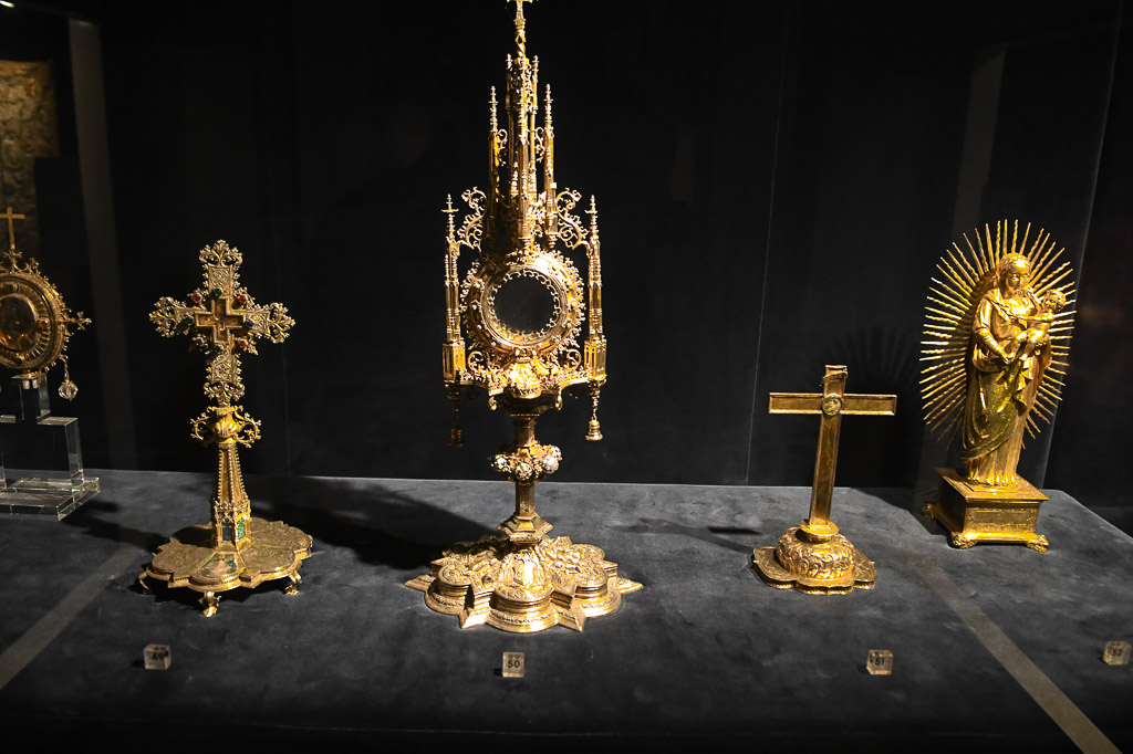 Goldene Monstranzen und Kreuze in einer Vitrine