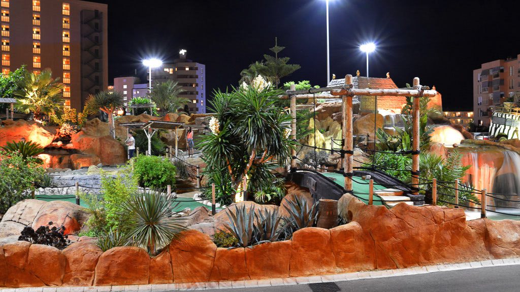 Minigolfanlage mit Palmen bei Nacht