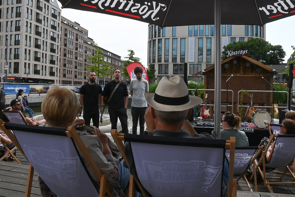 Besucher in Liegestühlen vor einer Bühne