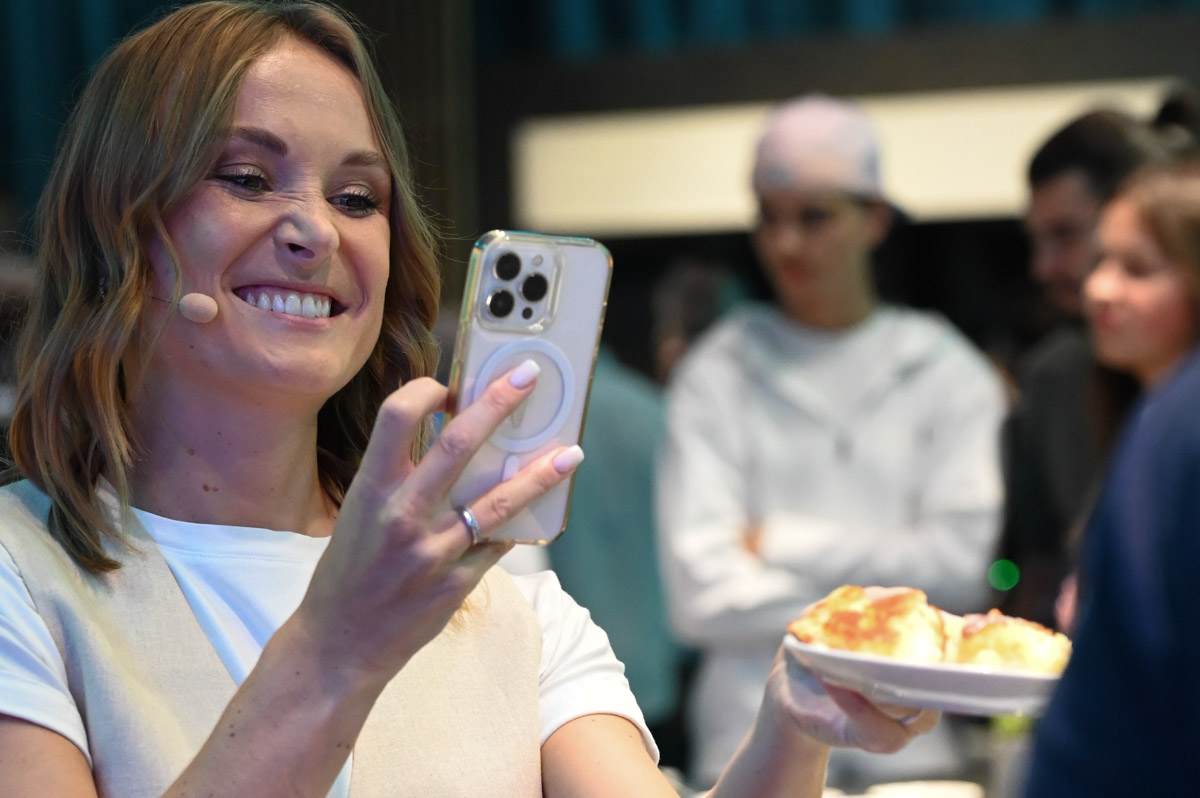 Besucherin mit Handy und Teller