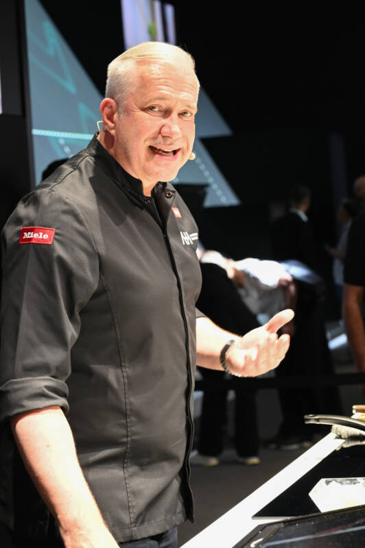 Sternekoch Alexander Herrmann beim Kochen auf der Bühne im Hochformat