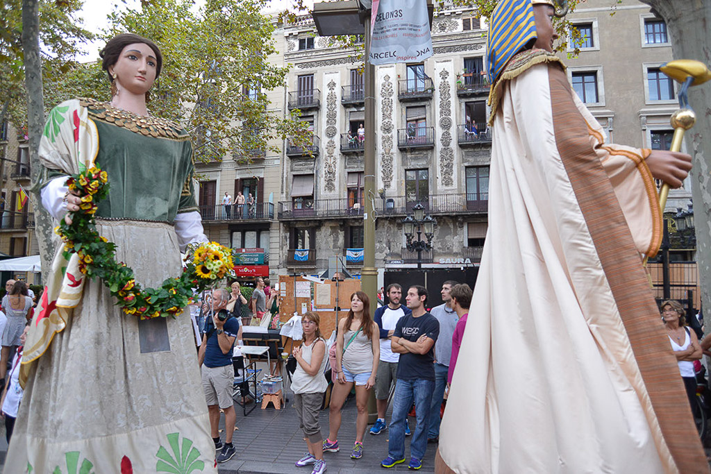 Riesenfigur einer Königin mit Blumenkranz neben einer weißen Figur