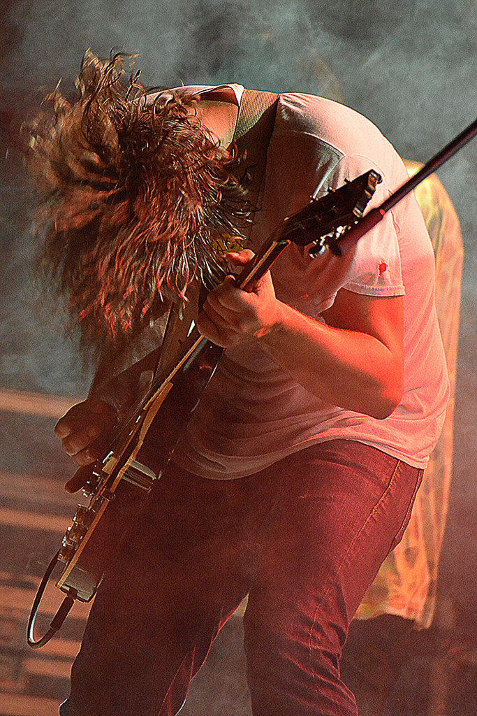 Musiker mit langem Haar spielt Gitarre