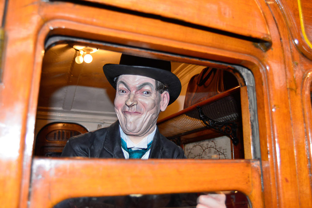 Figur eines Schaffners in einem orangefarbenen Bus