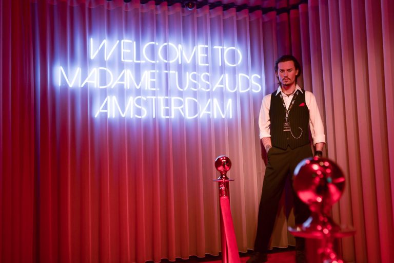 Leuchtschrift Welcome to Madame Tussauds Amsterdam mit einer Wachsfigur
