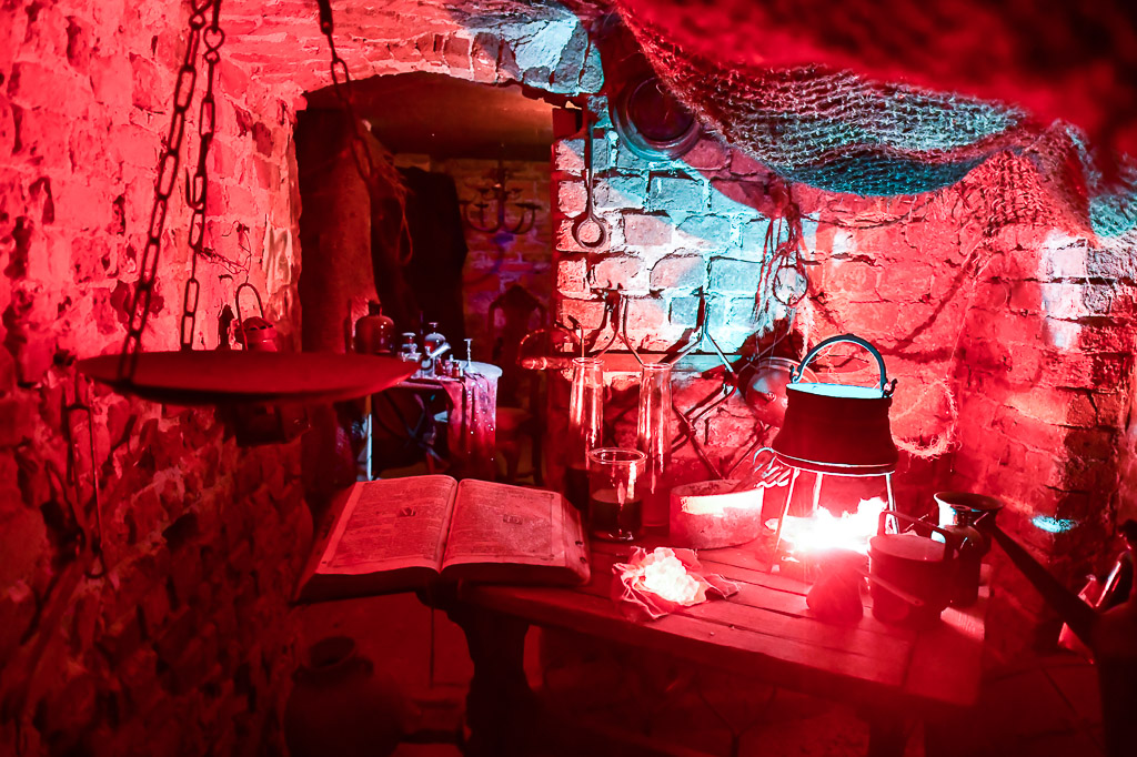 Raum mit rotem Licht und Zauberutensilien