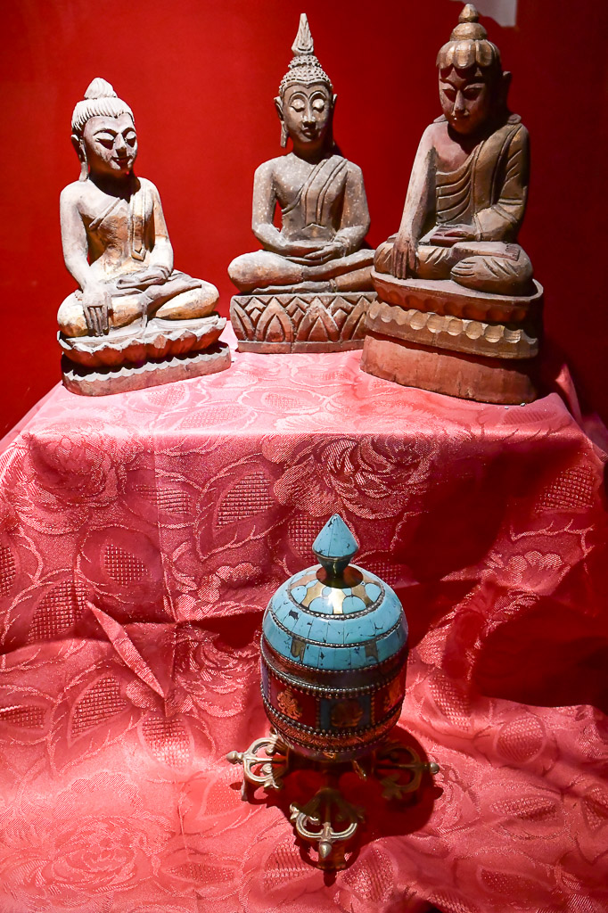 Buddha-Figuren auf rotem Tuch im Hochformat