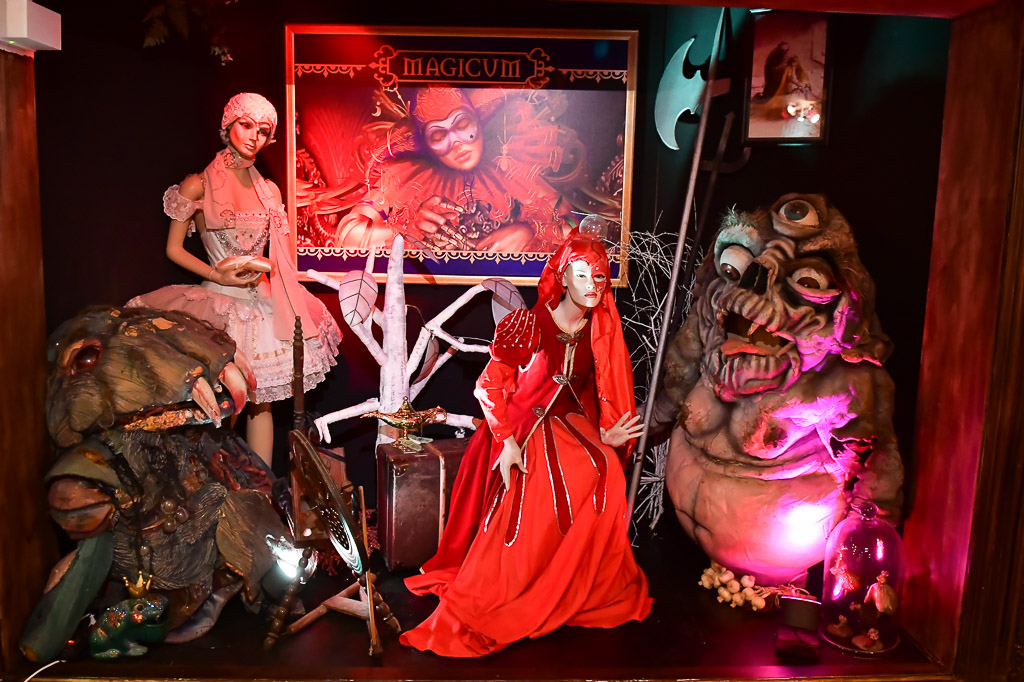 Figurengruppe mit roter Gestalt im farbigen Licht