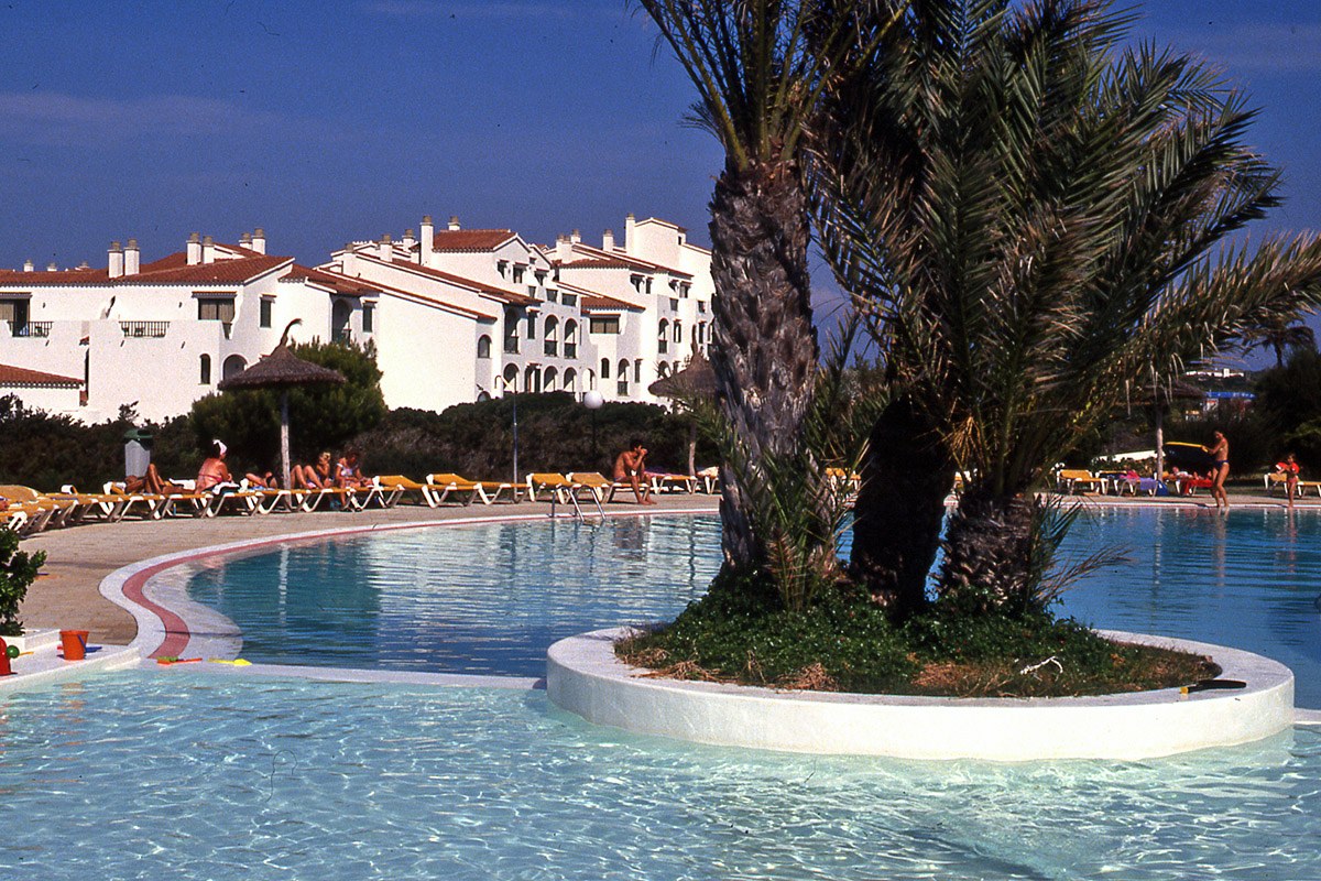 Pool mit Palmeninsel vor den Apartmenthäusern