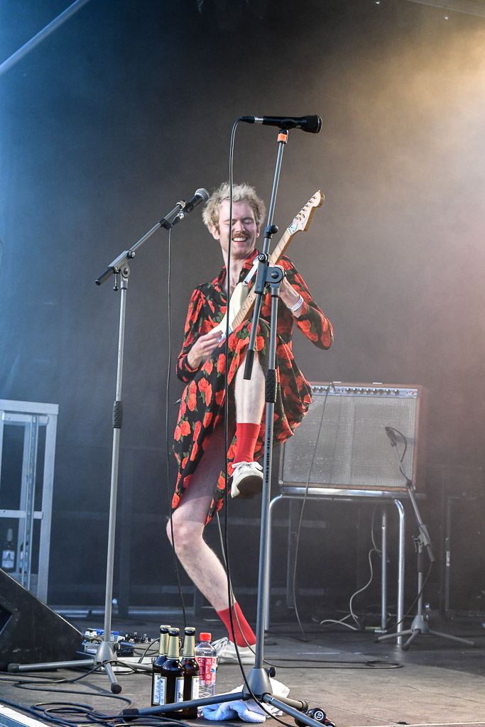 Gitarrist von LOVEMACHINE im Rosenkleid im Hochformat
