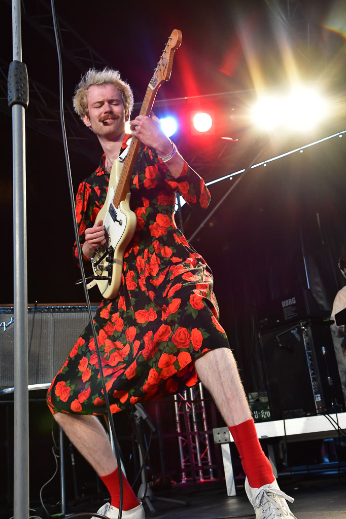 Gitarrist von LOVEMACHINE im Rosenkleid im Hochformat