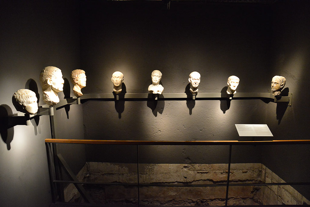 Marmorbüsten in einer Vitrine in einem dunklen Raum