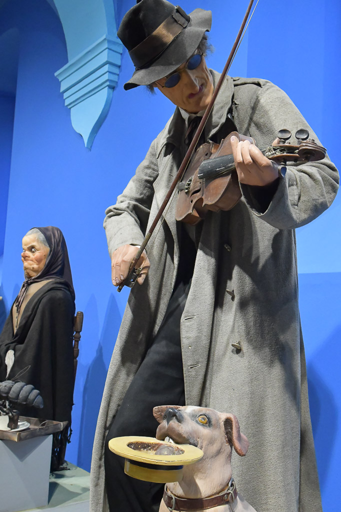 Figur eines Geigers vor blauer Wand
