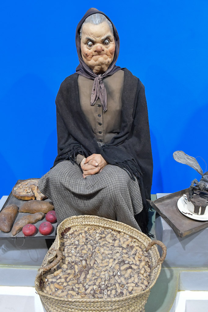 Figur einer alten Frau mit einem Korb