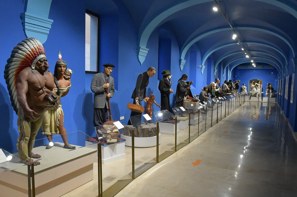 Galerie mit Figuren entlang eines Ganges mit blauen Wänden