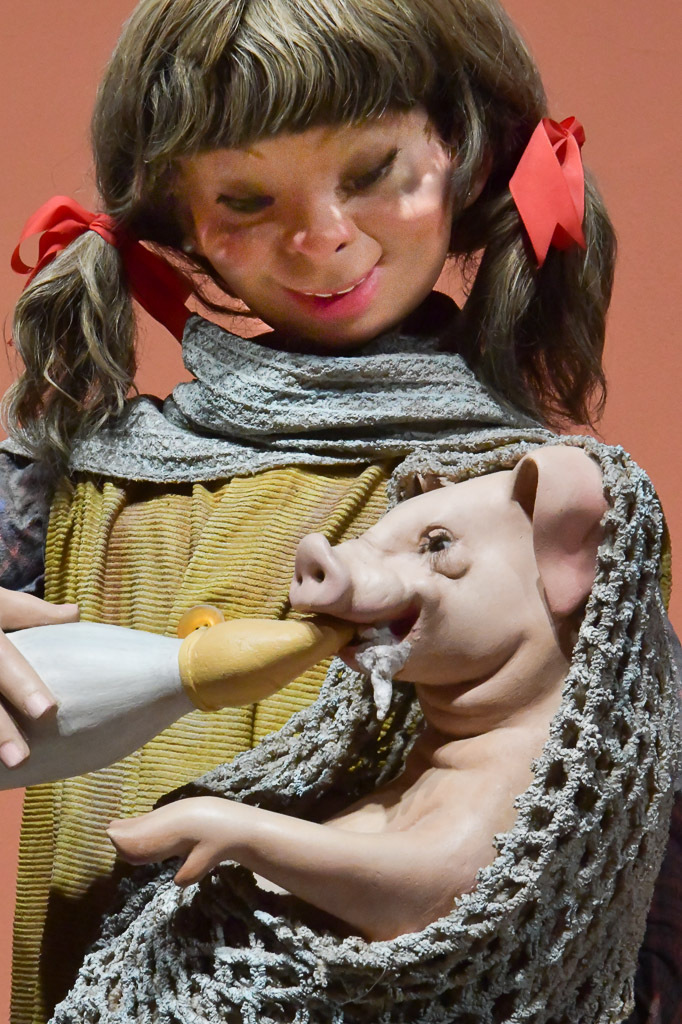 Figur eines Mädchens mit einem Ferkel