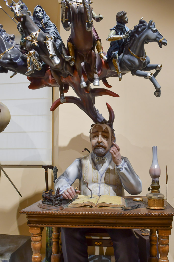 Figur eines Mannes an einem Schreibtisch vor Reitern