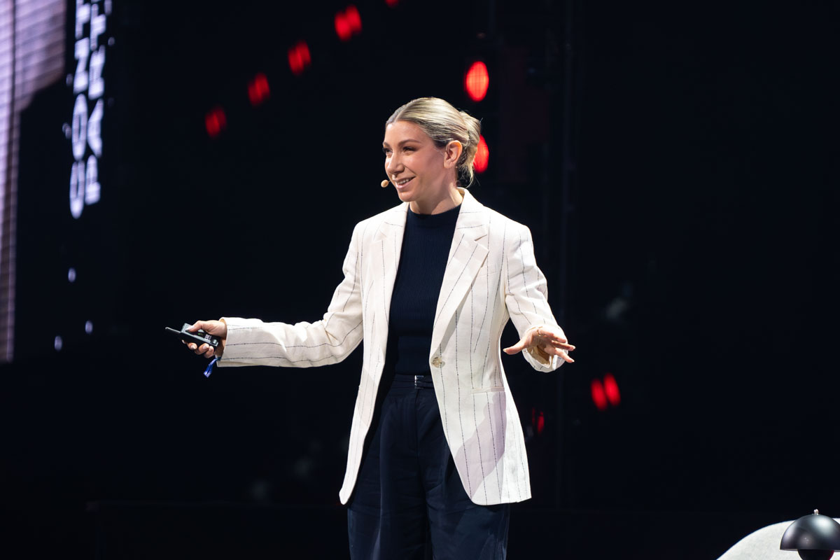Speakerin im weißen Blazer auf der Bühne