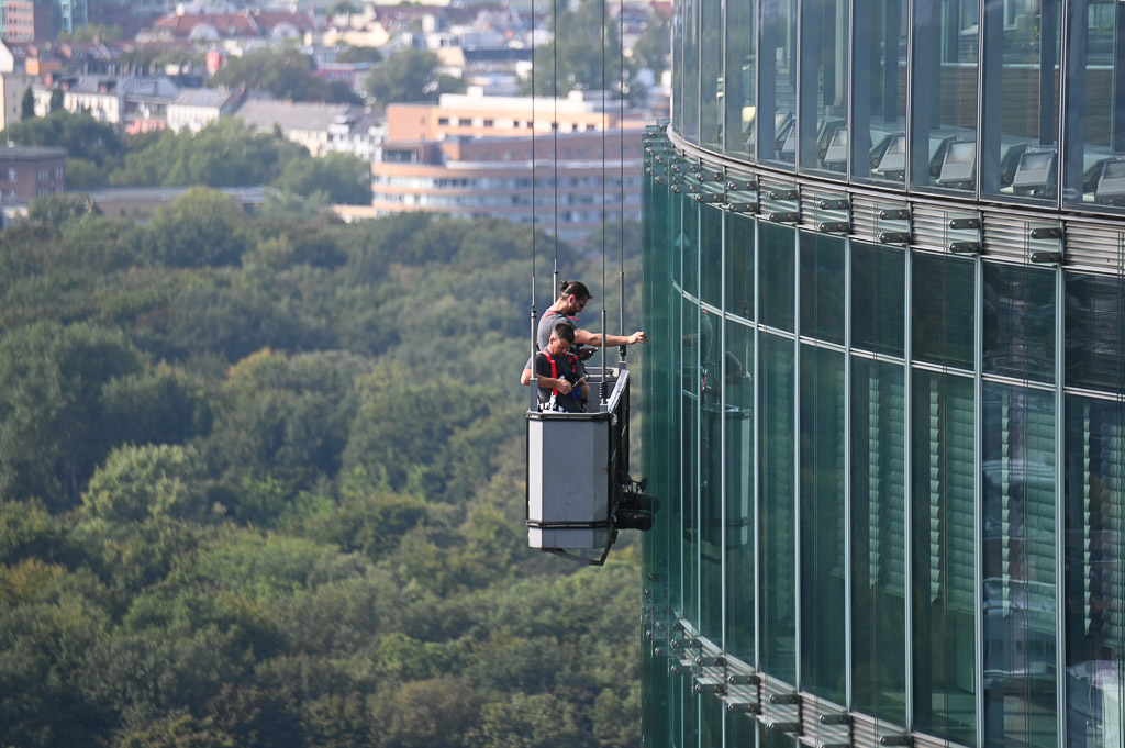 Mensch an einer Hochhausfassade