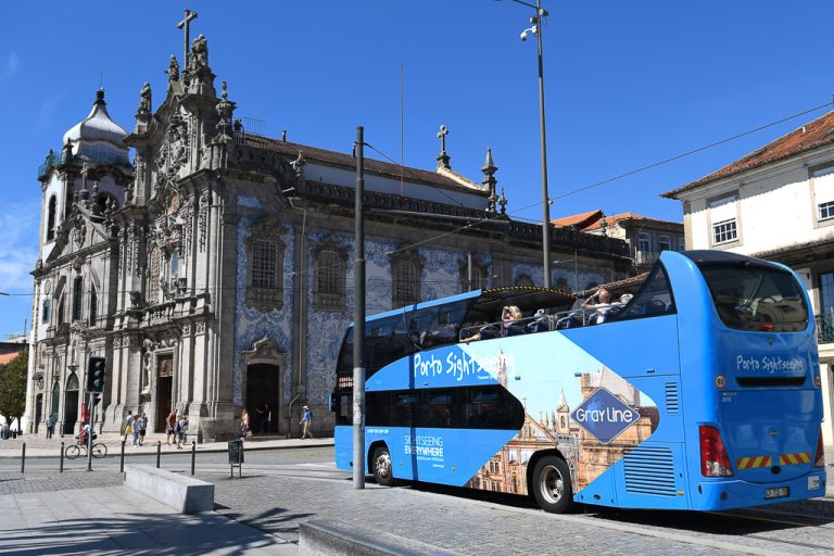 Blauer Porto-Sightseeing-Bus vor einer Kirche
