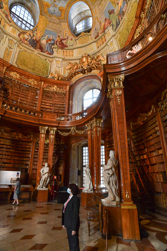 Saal mit Statue und Bücherregalen im Hochformat