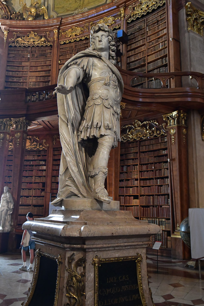 Marmorstatue neben Bücherregalen im Hochformat